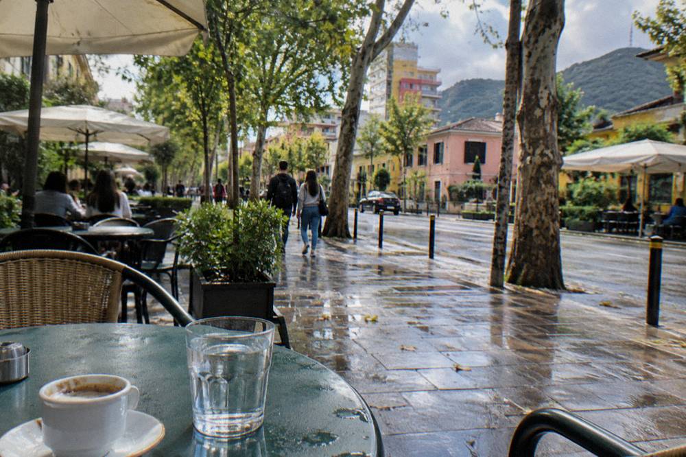 A small cup of Turkish style coffee and a glass of water on a cafe table