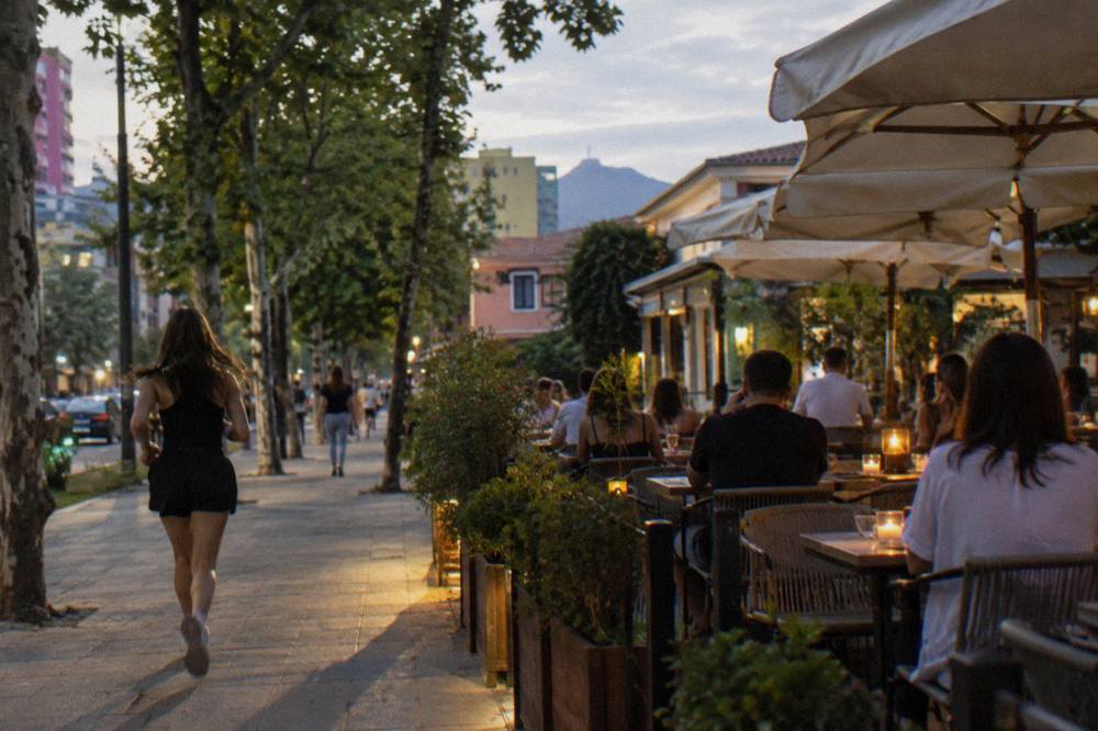 Diners at candlelit tables on a terrace in the Blloku district at dusk