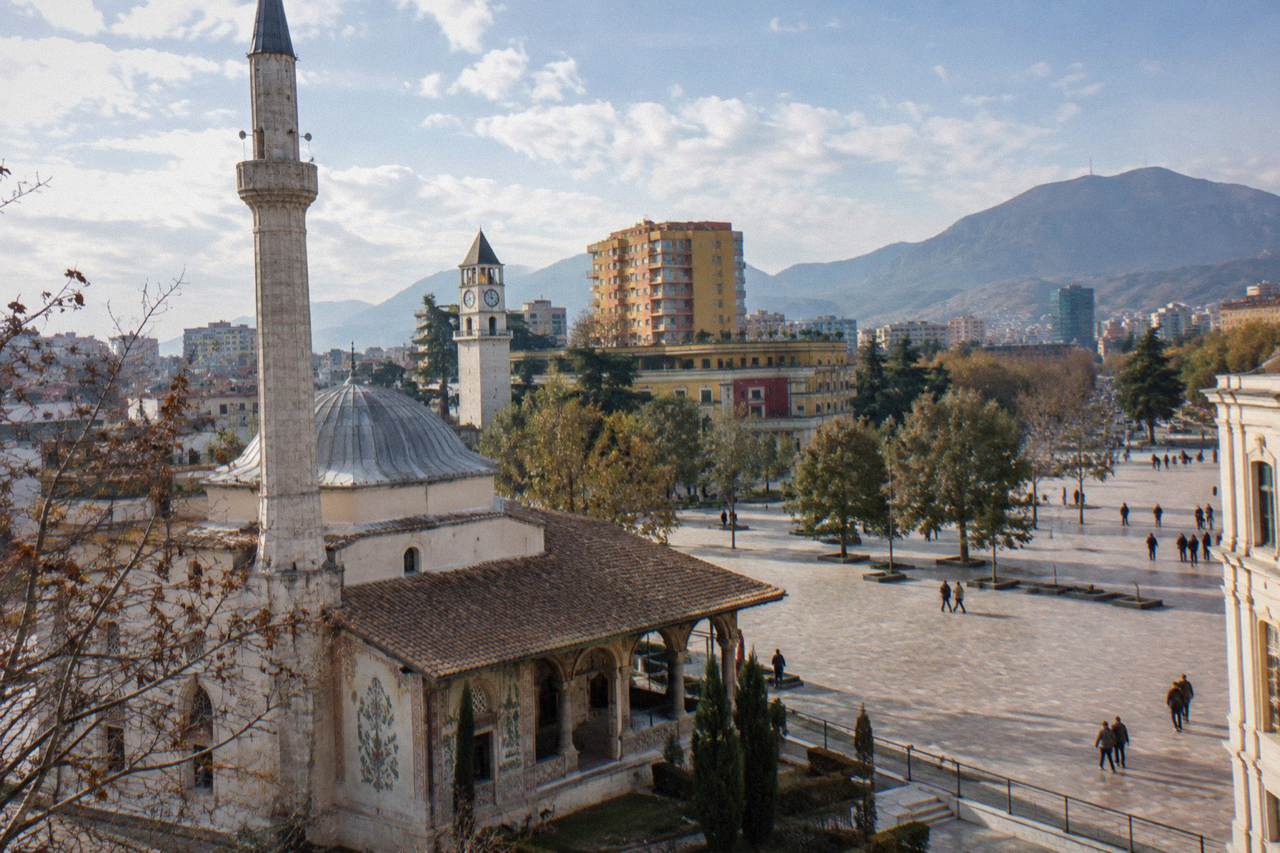Skanderbeg Square in Tirana under a clear sky with the Clock Tower and Et'hem Bey Mosque