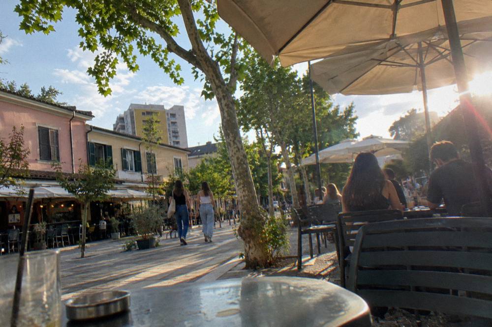 Cafe tables and sun umbrellas on a warm evening in the Blloku district of Tirana