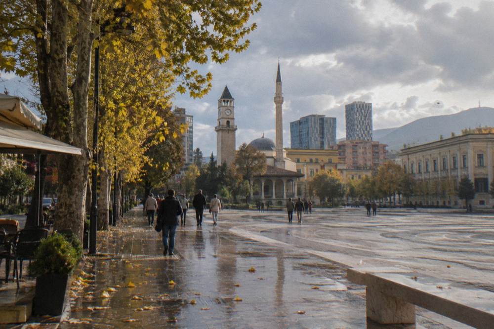 Autumn leaves along a boulevard in Tirana with the Clock Tower in the background