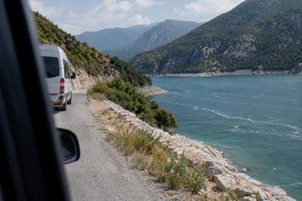 A tour van on a mountain road above Lake Bovilla near Tirana