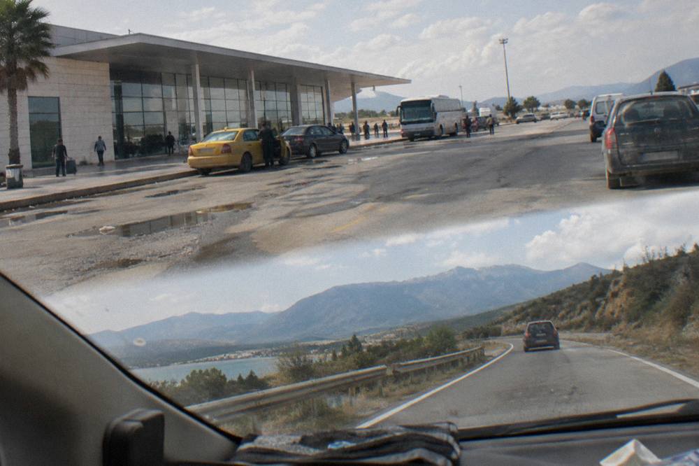 A hire car on an open road between hills heading towards the Albanian mountains