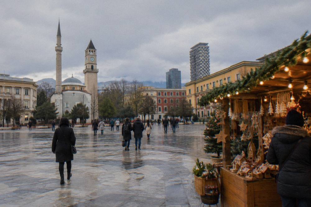 A lit Christmas market stall with wooden gifts and decorations in central Tirana