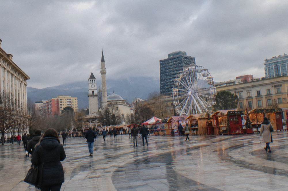 Festive stalls and a ferris wheel on a city square in December