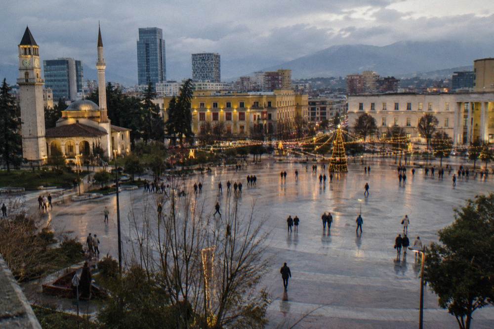 Festive lights over a city square at dusk