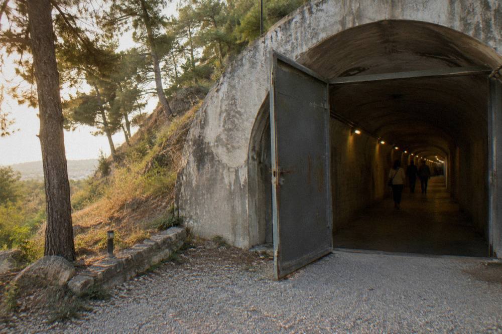 Long concrete tunnel inside a converted bunker museum with exhibition lighting