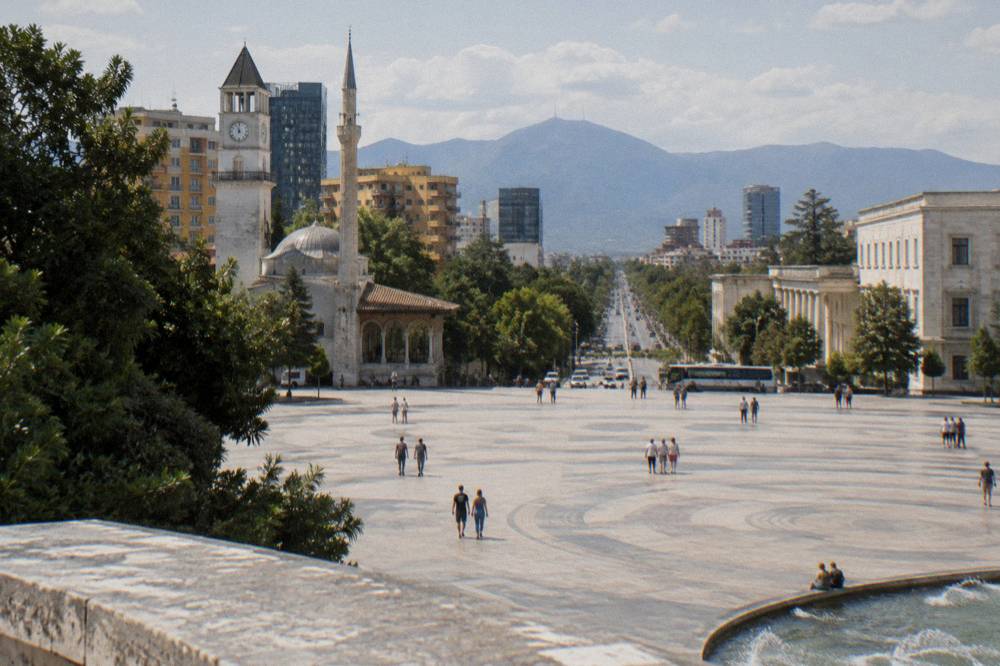 A highway leading out of Tirana with mountains rising on the horizon