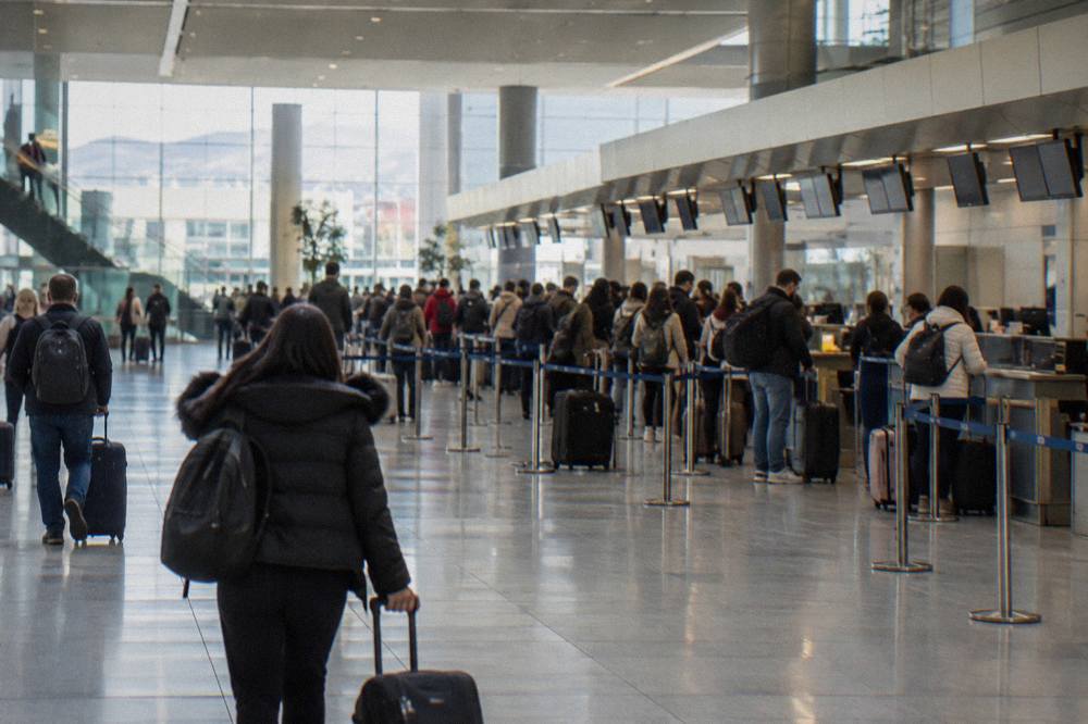 The departures hall of Tirana airport with check-in desks and travellers with luggage