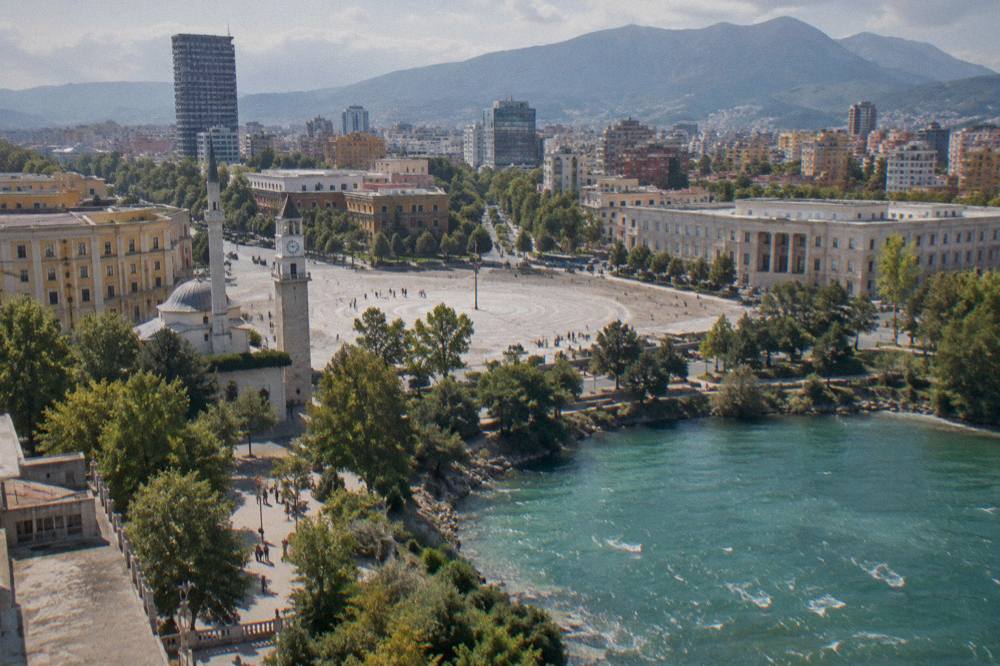 Aerial view of a turquoise mountain lake ringed by rocky hills near Tirana