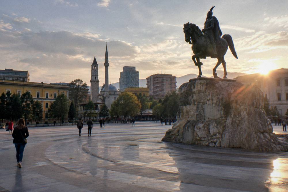 The floodlit equestrian statue of Skanderbeg on Skanderbeg Square at dusk in Tirana