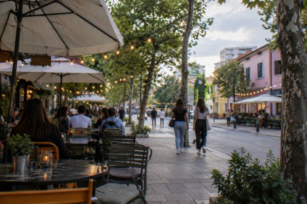 Cafe terraces and string lights on an evening street in the Blloku quarter of Tirana