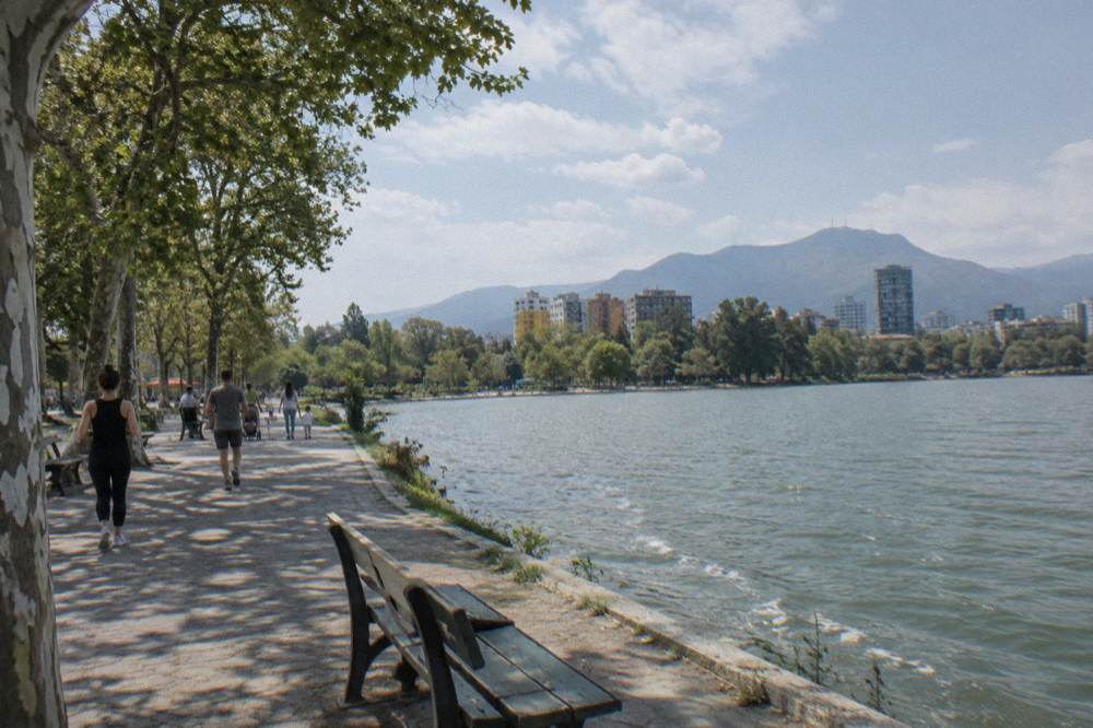 Families and joggers on the path around the artificial lake in the Grand Park of Tirana