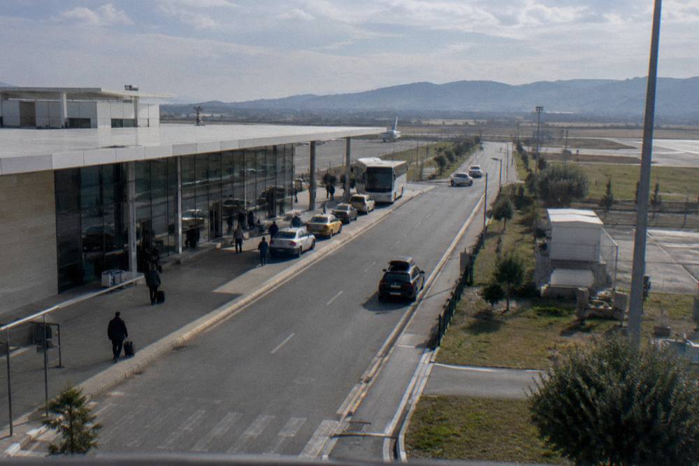 The road from Rinas toward the Tirana basin with hills on the horizon