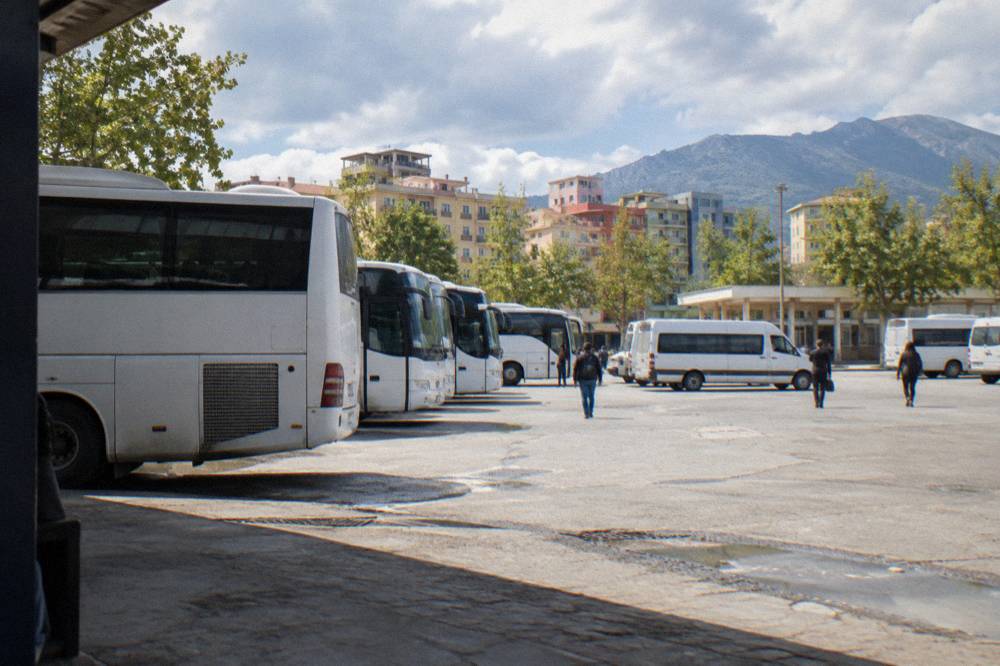 Minibuses and coaches parked side by side at an intercity bus terminal in Albania