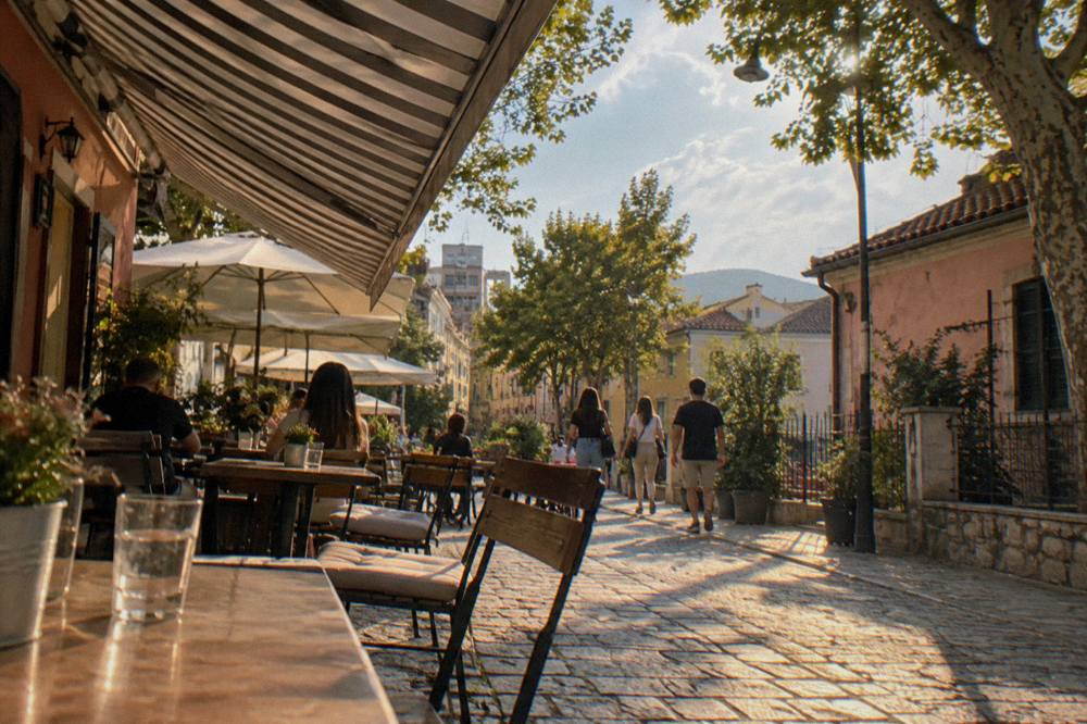 Cafe terrace with striped awning on a stone street in an Albanian old town