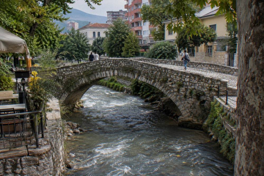 The stone arches of Tanners' Bridge, an Ottoman-era footbridge on a Tirana side street