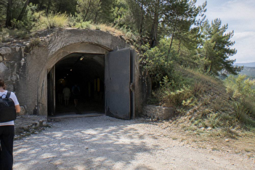 The dark concrete entrance corridor of a bunker museum in Tirana lit by spotlights