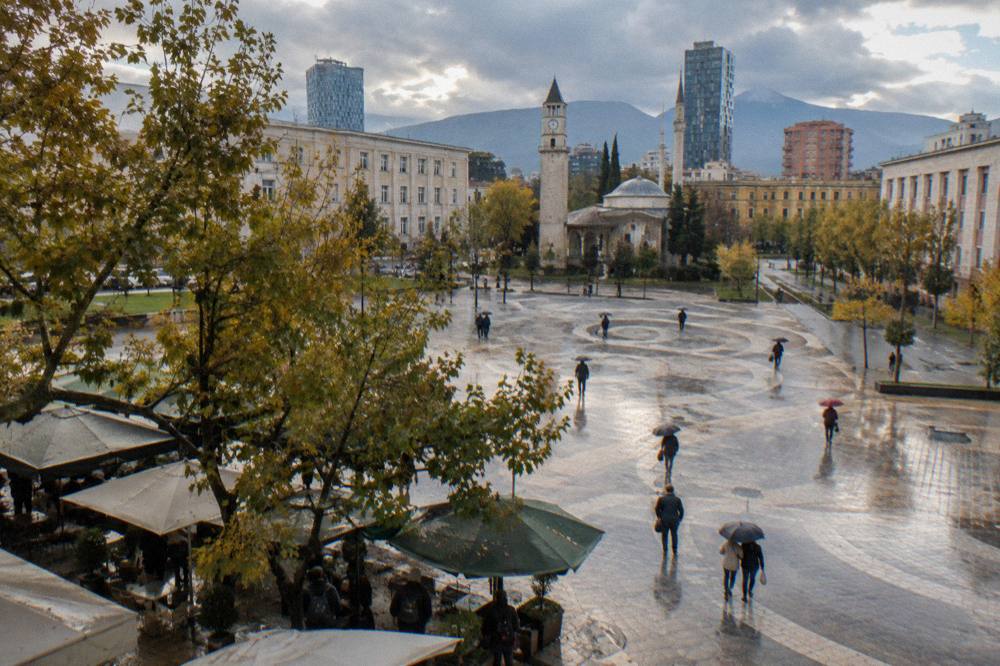 An umbrella-covered street in Tirana on a rainy autumn afternoon