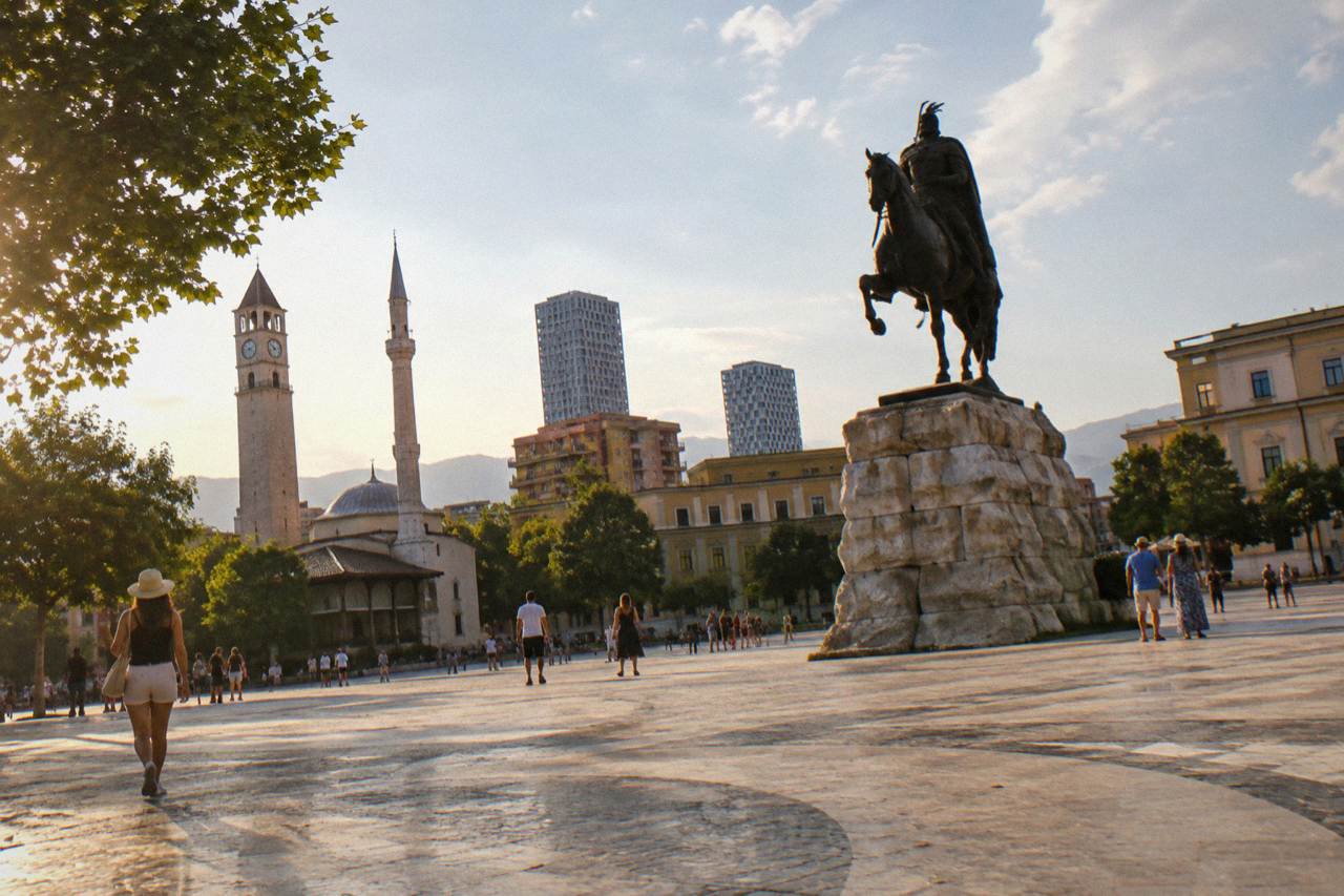 Skanderbeg Square in Tirana under a bright summer sky with the equestrian statue in the centre