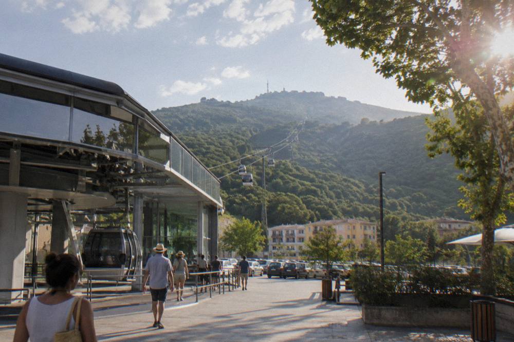 Cable car cabins travelling up the green slope of Mount Dajti above Tirana