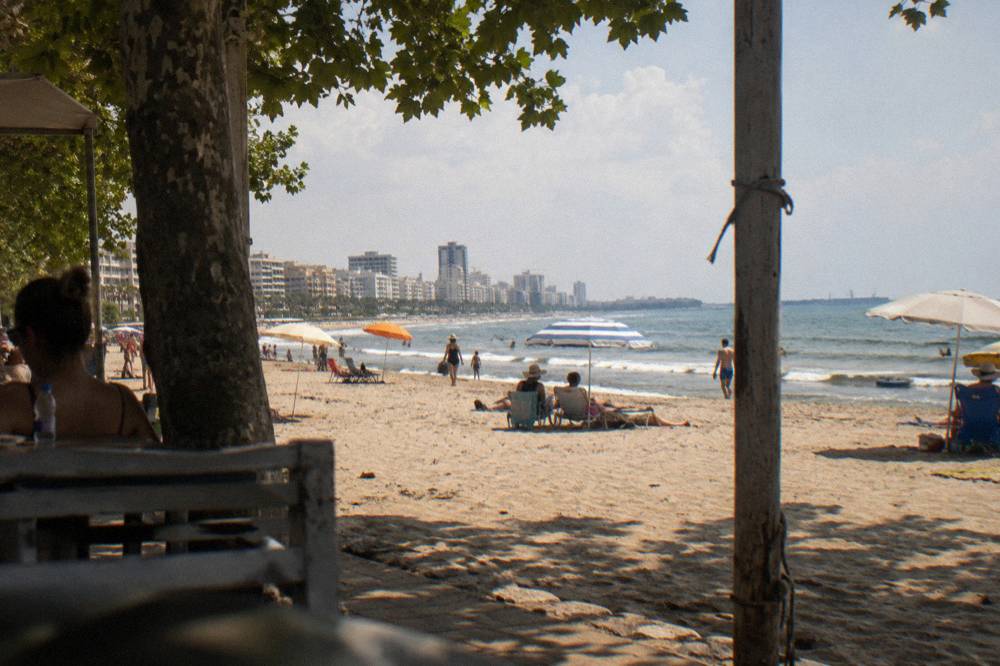 People on a wide sandy Adriatic beach near Durres with umbrellas in the sun