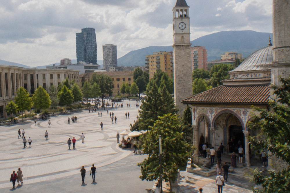 worshippers and visitors at the painted entrance of a mosque in Tirana
