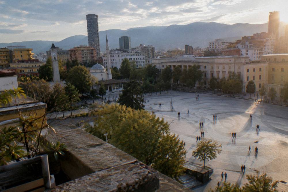 Evening light over the domes and rooftops of central Tirana seen from above