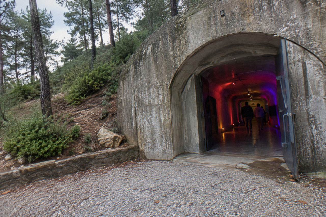 The entrance corridor of a converted bunker museum lit with coloured lights in Tirana