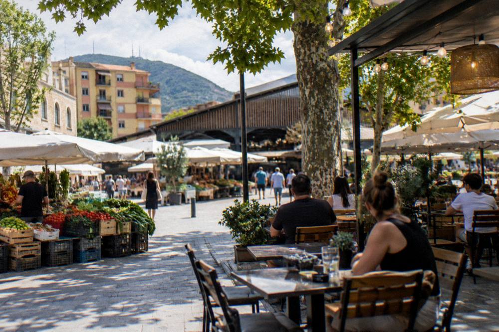 A lively restaurant terrace with diners and hanging lights in the New Bazaar quarter of Tirana
