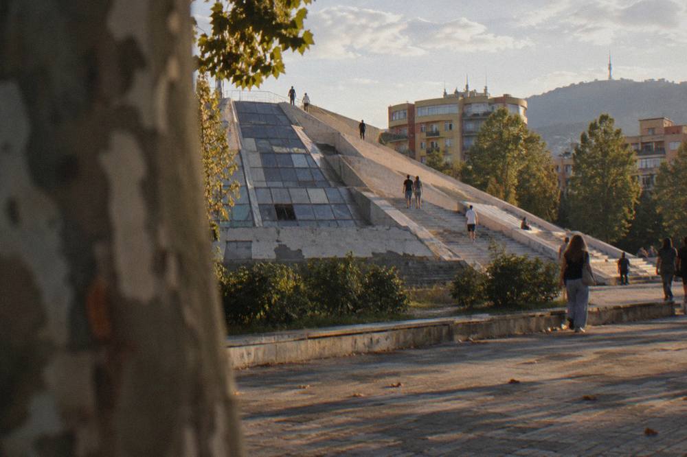 Visitors walking on the stepped facade of the Pyramid of Tirana