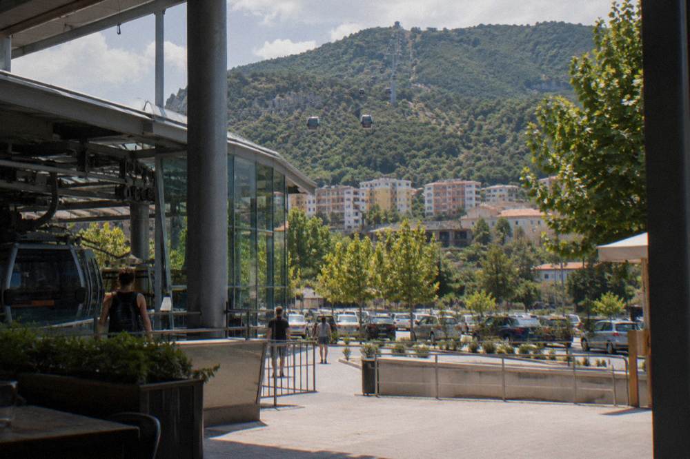 Cable car cabins travelling up the green slope of Mount Dajti above Tirana