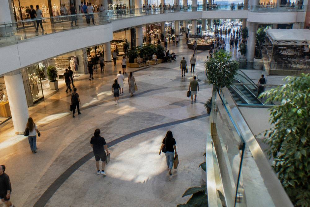 People walking through a bright shopping mall atrium in Tirana
