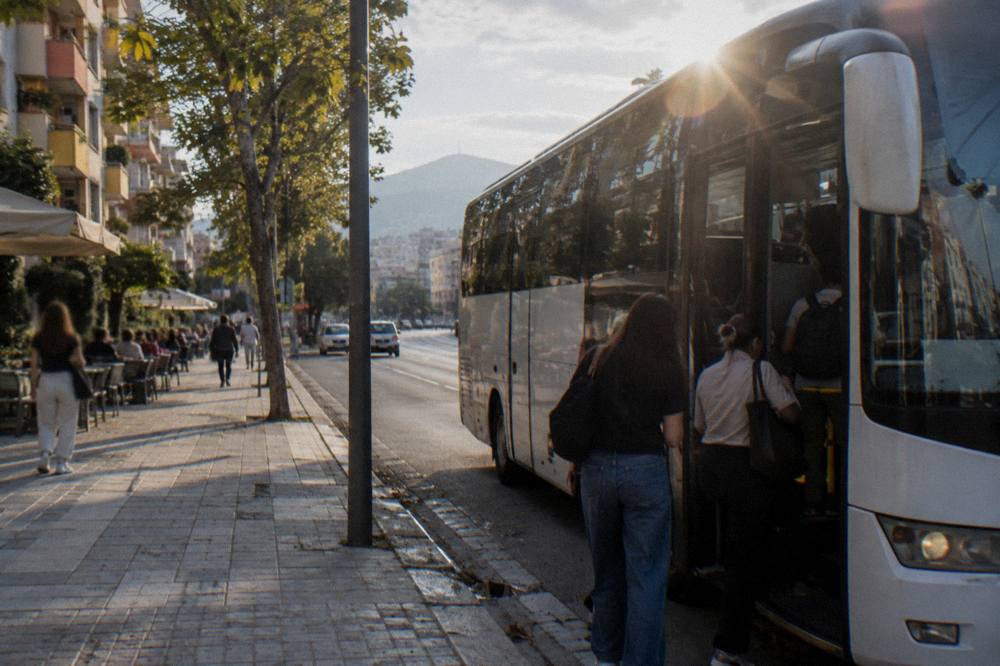A bus parked at an airport terminal kerb with passengers boarding