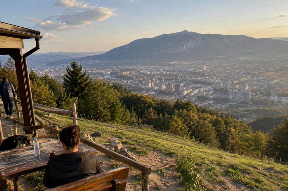 A view over Tirana's rooftops with Mount Dajti rising behind the city under a clear sky