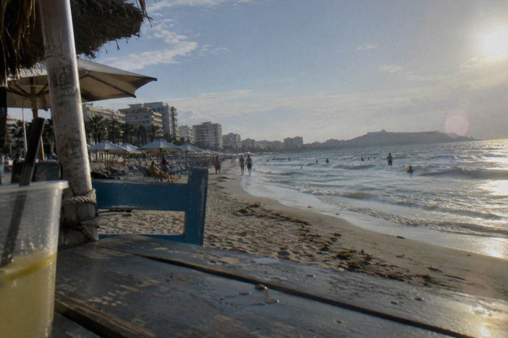A long sandy Adriatic beach with umbrellas and a promenade at Durres