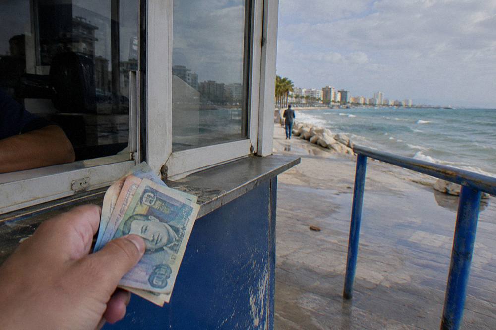 Albanian lek banknotes held out for a bus fare at a ticket window
