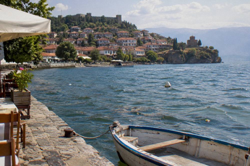 An old stone village on a small peninsula jutting into a calm mountain lake