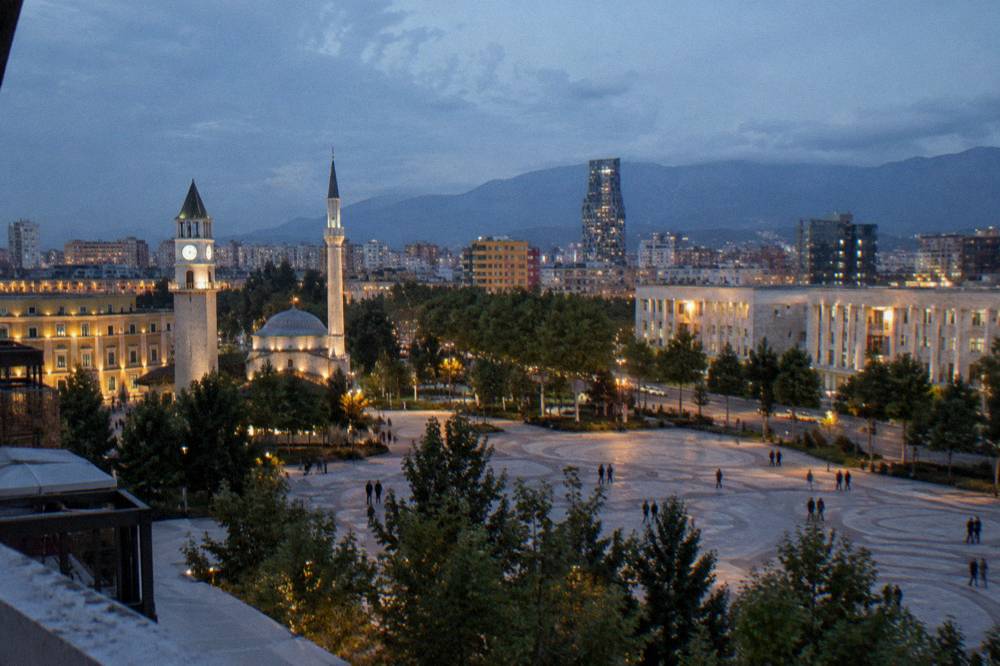 Evening lights over rooftops and streets in central Tirana seen from above