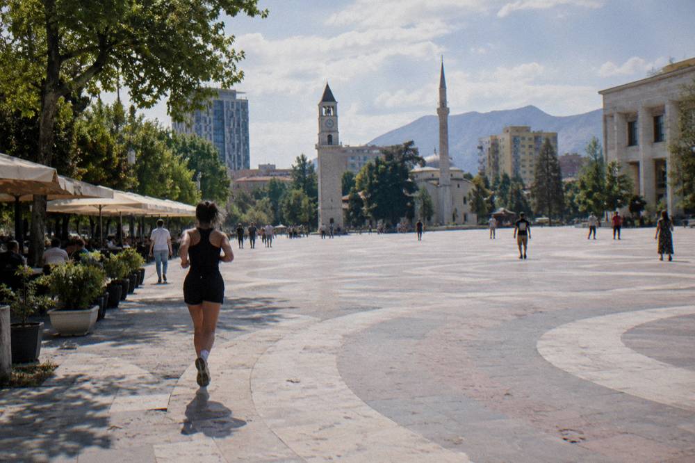 Sunny street in Tirana with cafe umbrellas and plane trees