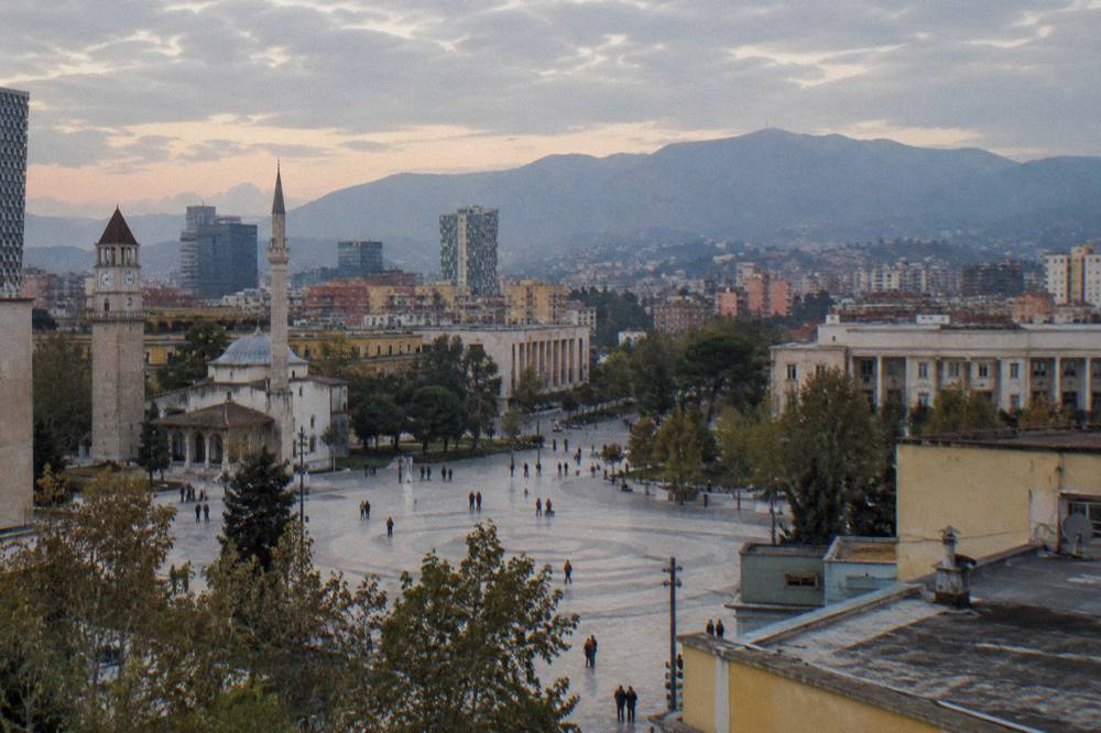 Rooftop view over Tirana rooftops toward the hills of Mount Dajti at dusk