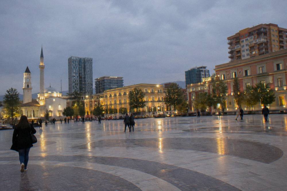 Illuminated buildings around Skanderbeg Square in Tirana after dark