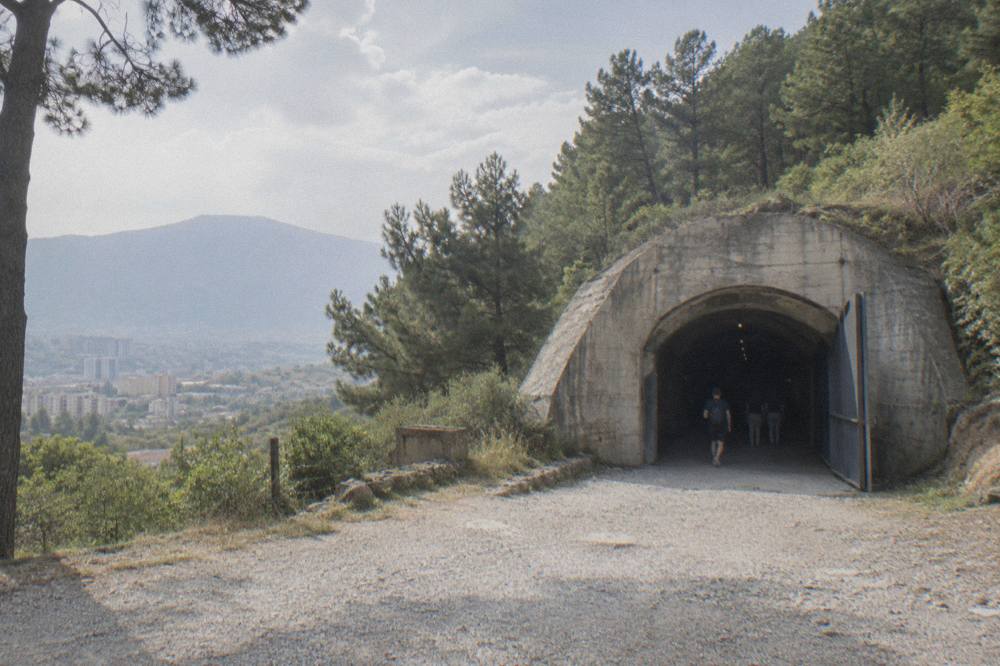 Dim concrete tunnel of a converted bunker museum with exhibit lighting along the walls