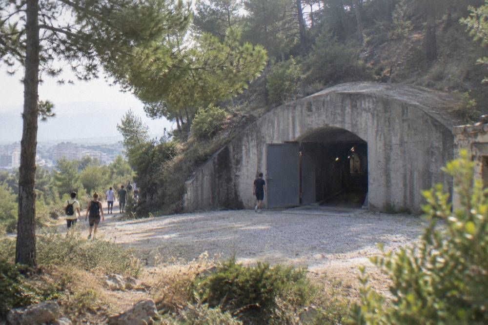 The dark tunnel entrance and concrete corridors of an underground bunker museum lit for visitors
