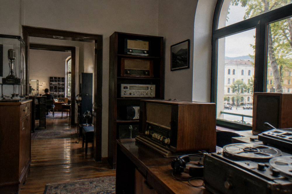 A preserved listening room with old radios and recording equipment in the House of Leaves museum