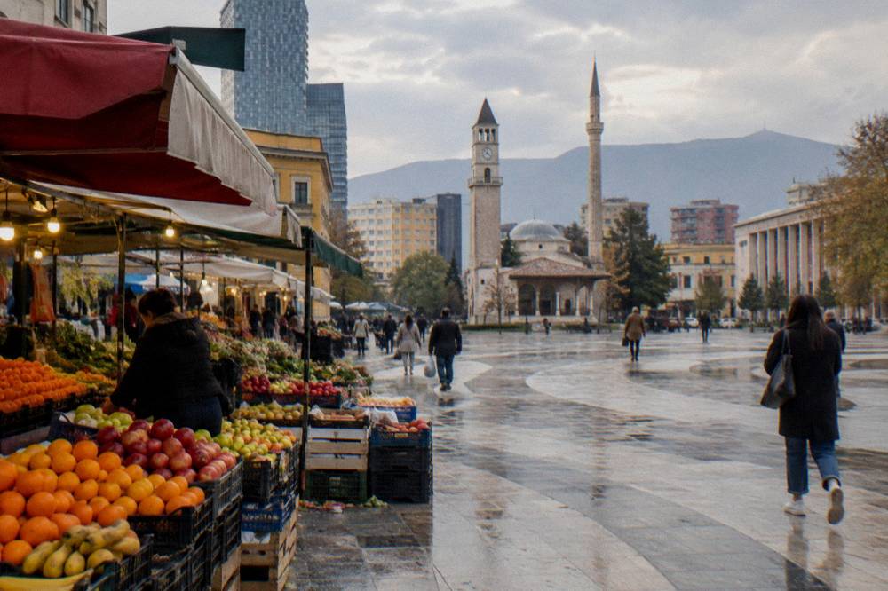 A market alley with fruit stalls and awnings in late afternoon light